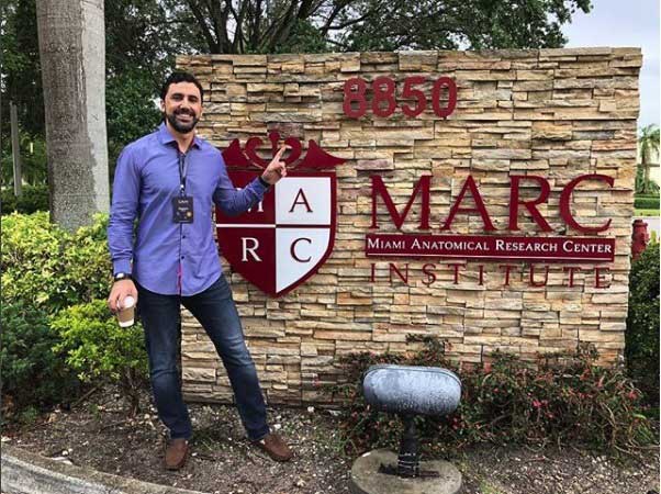 dr roberto chacur em frente a placa de entrada do marc institute onde participou do gain da galderma nos eua